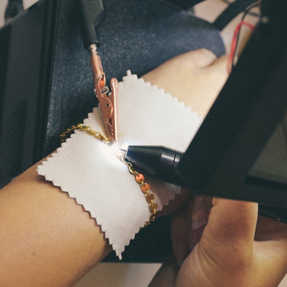 permanent jewelry being performed with spark 